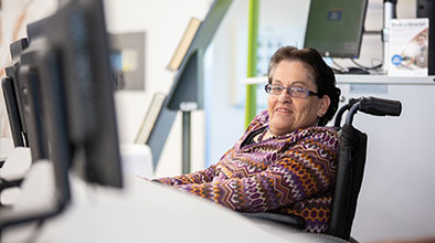 Photo of a customer smiling at a library computer.