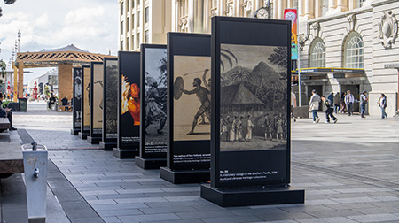Large lightbox display of Pacific heritage image boards outside Britomart Station