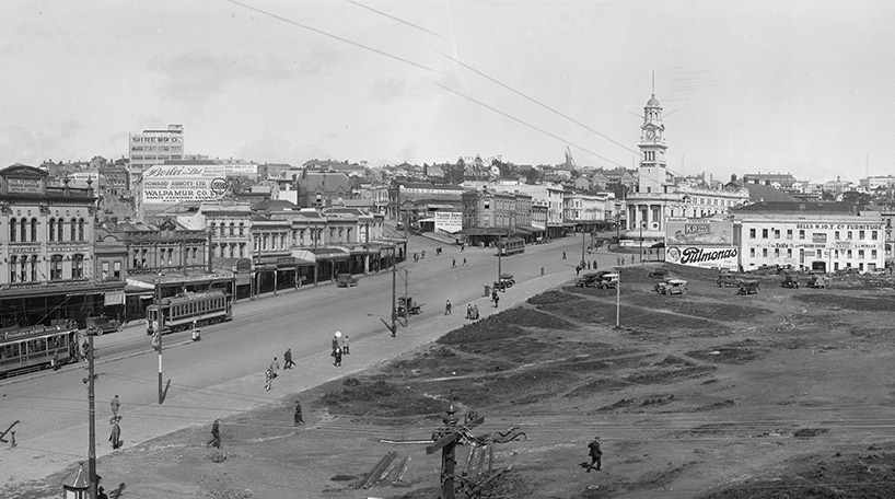 A black and white photo of Queen Street and Civic Square in Auckland. This is part of the Auckland Council Libraries heritage collections.