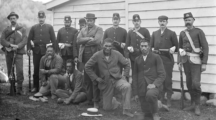 A black and white photo of police guarding a few men. This is part of the Auckland Council Libraries heritage collections.