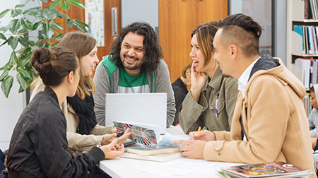 A group of people discussing a book at a library.
