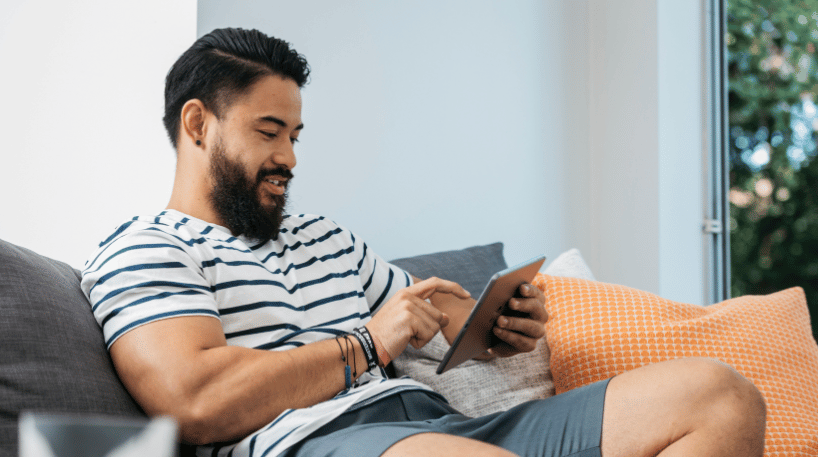 Man relaxing at home browsing content on his iPad.