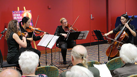 Musicians playing string instruments in Central City Library.