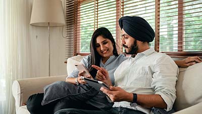 Couple talking while using devices.