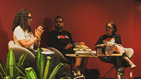 Podcast guests Dr Gina Cole and Dan Taipua speaking on stage with librarian Ineka Vogels.