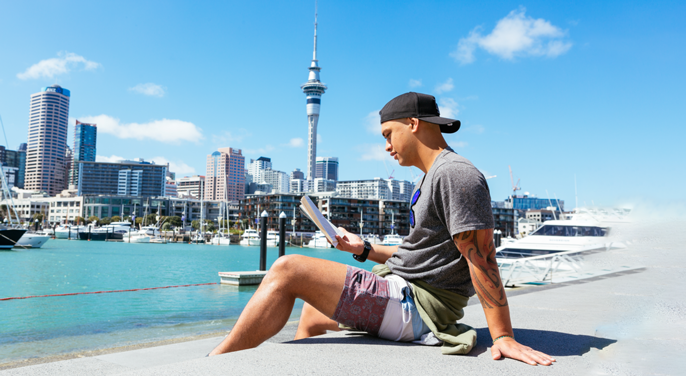 A man reads in the sun at the Auckland City Viaduct.