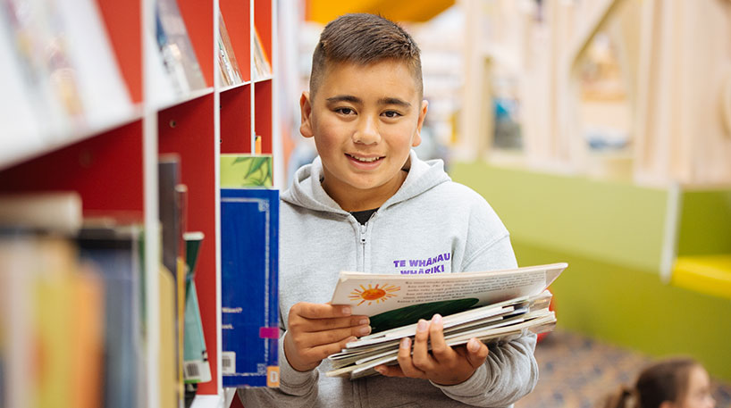 Young boy choosing books in a library