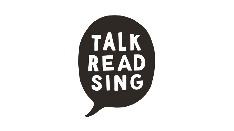 Image shows a black speech bubble with the words Talk, Read, Sing inside it.