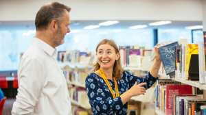Staff and customer talking in the library.