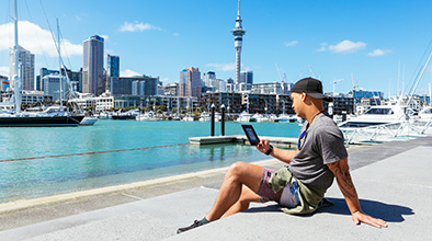 Person reading on an eBook on a sunny day at Auckland Viaduct.