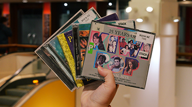 A hand holding up a fanned out array of CD covers