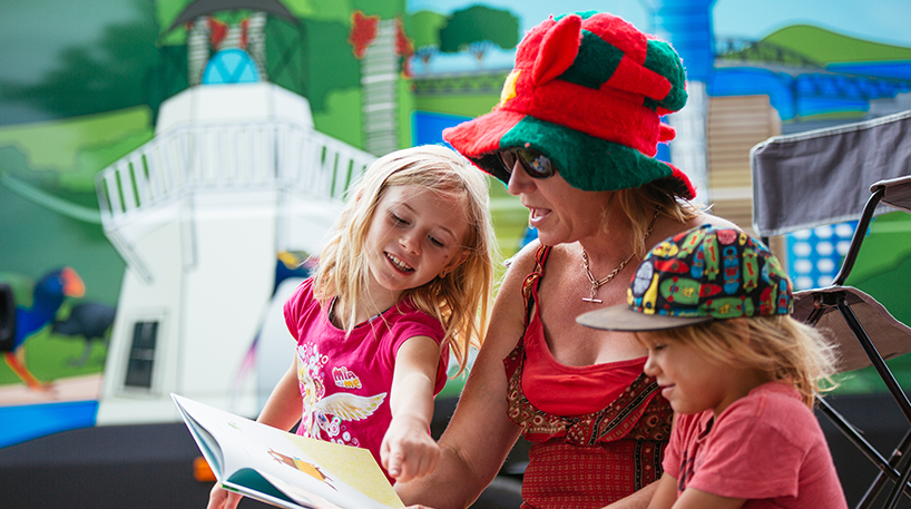 Children reading outdoors in summer